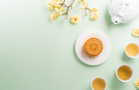 Chinese Mid-Autumn Festival concept made from mooncakes, tea and plum blossom on pastel background.の写真素材