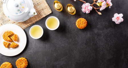 Chinese Mid-Autumn Festival concept made from mooncakes, tea and plum blossom. Chinese characters FU in the article refer to fortune good luck, wealth, money flow.の写真素材