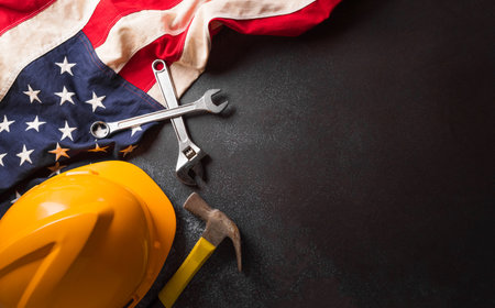 Happy Labor day concept. American flag with different construction tools on dark background.の写真素材