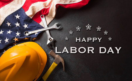 Happy Labor day concept. American flag and different construction tools with the text on dark background.の写真素材