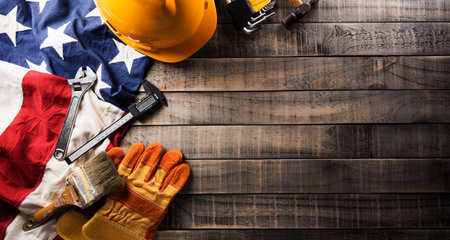 Happy Labor day concept. American flag with different construction tools on dark wooden background.の写真素材