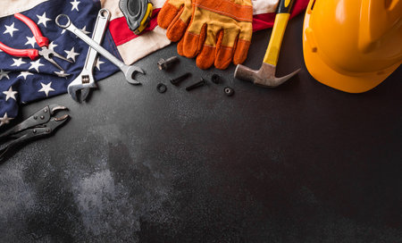 Happy Labor day concept. American flag with different construction tools on dark background.の写真素材