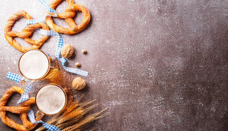 festival decoration symbols made from Pretzel loaf, beer, sausage, potato chips and Bavarian white and blue fabric on dark stone background.の写真素材