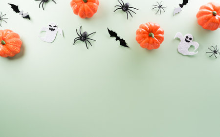 Halloween decorations made from pumpkin, paper bats, black spider on pastel orange backgroundの写真素材