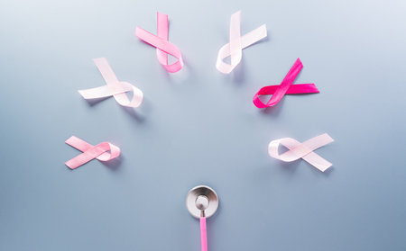 Pink ribbon on pastel paper background for supporting breast cancer awareness month campaign.の写真素材
