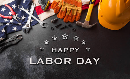 Happy Labor day concept. American flag with different construction tools and the text on dark background.の写真素材