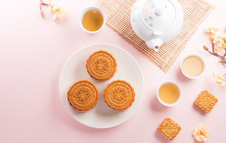 Chinese Mid-Autumn Festival concept made from mooncakes, tea and plum blossom on pastel background.の写真素材