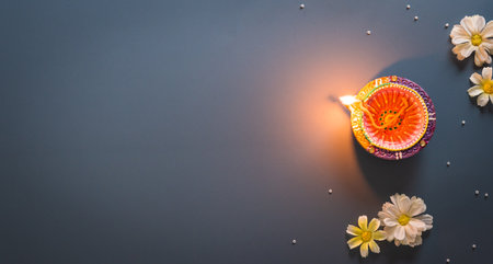 Happy Diwali - Clay Diya lamps lit during Diwali, Hindu festival of lights celebration. Colorful traditional oil lamp diya on blue backgroundの写真素材