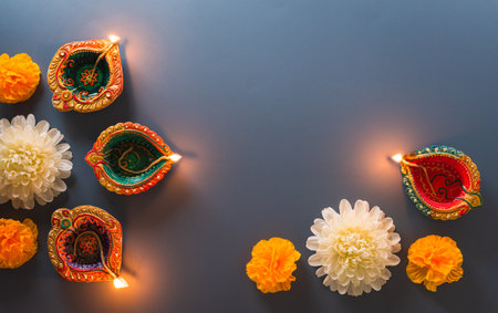 Happy Diwali - Clay Diya lamps lit during Diwali, Hindu festival of lights celebration. Colorful traditional oil lamp diya on blue backgroundの写真素材