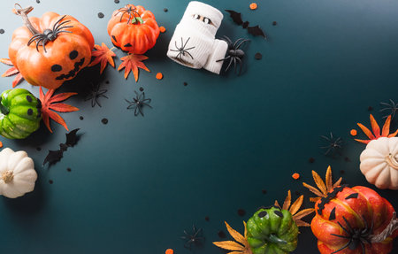 Halloween decorations made from pumpkin, paper bats, black spider on dark backgroundの写真素材