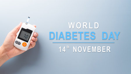 Healthcare and medical concept, Top view hand holding blood glucose meter test on pastel blue background. World Diabetes day, 14 November.の写真素材