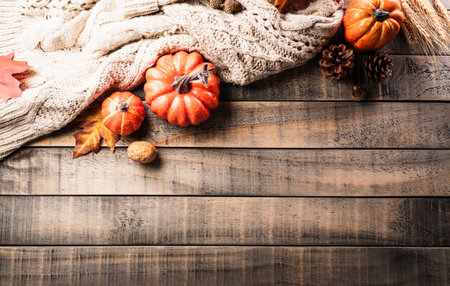 Autumn and thanksgiving decoration concept made from autumn leaves and pumpkin on dark wooden background. Flat lay, top view with copy space.の写真素材