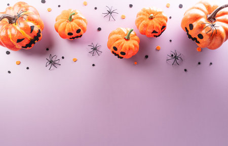 Halloween decorations made from pumpkin, paper bats, black spider on pastel backgroundの写真素材
