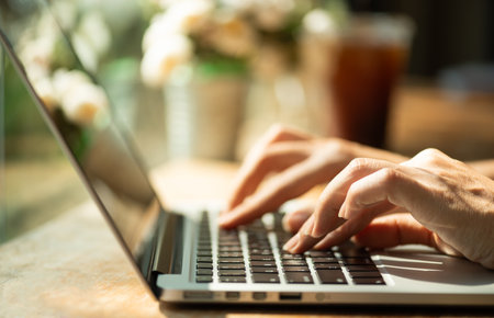 Closeup female hands typing on laptop keyboard. Woman working at home office concept.の写真素材