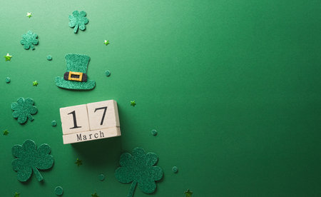 Happy St Patrick's Day decoration concept made from shamrocks ( clover leaf), wooden calendar and leprechaun hat on green background.の写真素材