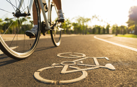 Close up image on road with athletic women cyclist legs riding Mountain Bike in background at the morning.の写真素材