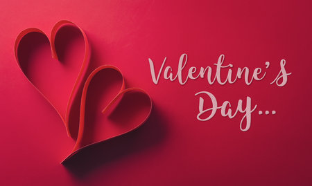 Love and Valentine's day concept made from paper hearts on dark red background.の写真素材
