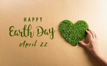 Hands holding green heart on brown background. World environment day, earth day and save earth concept.の写真素材