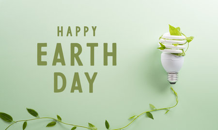 Green eco friendly concept made from light bulb and fresh leaves. Energy saving, ecology, earth day and environment sustainable resources conservation concept.の写真素材