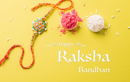 Raksha Bandhan, Indian festival with beautiful Rakhi and Rice Grains on yellow background. A traditional Indian wrist band which is a symbol of love between Sisters and Brothersの写真素材