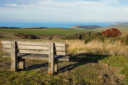 Empty wooden bench facing english countrysideの写真素材