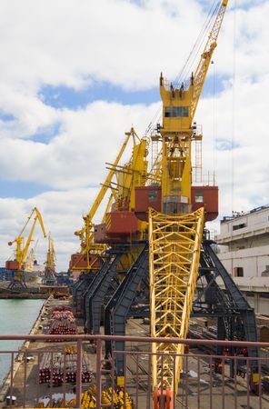 Several port cranes against the blue sky