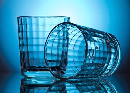 two faceted glass on blue backgroundの写真素材