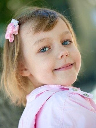 beautiful little girl in a pink raincoatの写真素材
