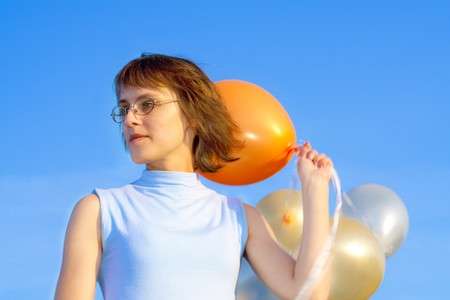 girl with air marbles on a background blue skyの写真素材