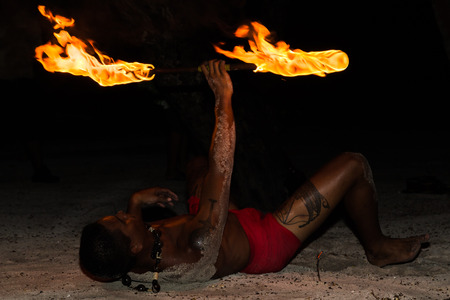 TAHAA, FRENCH POLYNESIA - CIRCA 2014: Polynesian man perform traditional fire dance circa 2014 in Tahaa.Fire dance is popular tourist attraction on luxury resorts of French Polynesia.のeditorial素材