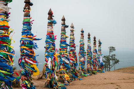 Colorful ribbons on wooden poles at Lake Baikal in Siberiaの写真素材