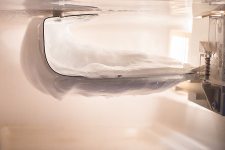 Ice buildup on the wall inside the freezer in a small refrigeratorの写真素材