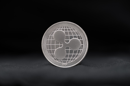 Ripple physical coin symbol on black backgroundの写真素材
