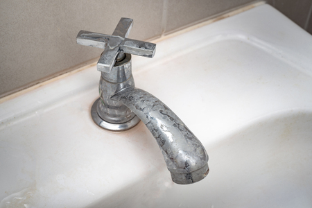 Dirty faucet with stain and limescale in bathroomの写真素材