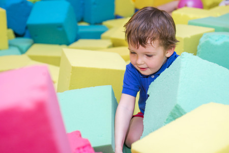 little kid play with soft blocks at indoor children playgroundの写真素材