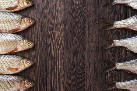Heads and tails of fish on a wooden tableの写真素材
