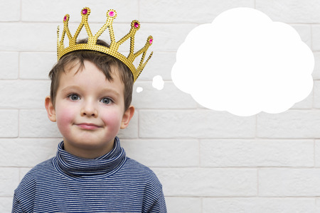 Small child in a crown with a think bubbleの写真素材