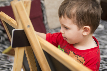 Child draws on a blackboardの写真素材