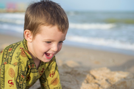 Happy laughing kid on sand beachの写真素材