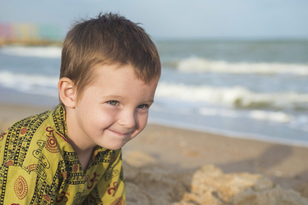 Kid playing on the beach. Cute little boy play with sand on beachの写真素材