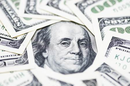 A circle of 100 dollar bills with a Franklin portrait in the center. Money background
