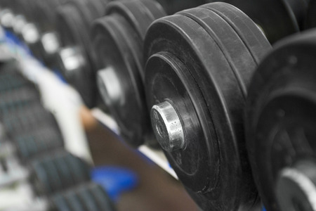 Rows of dumbbells in the gym. Dumbbells on the rack in the sports hall of the club