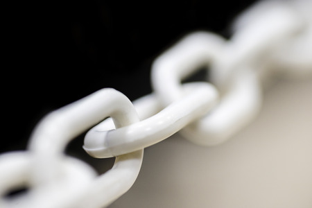 Close up white chain between light and dark background. Closeup white chainの写真素材