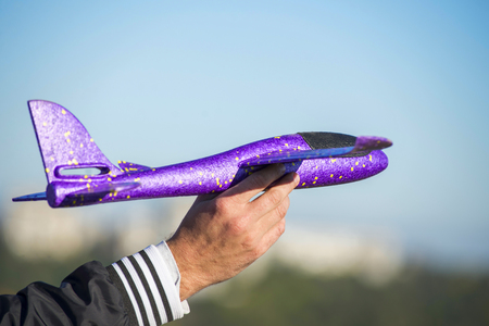 Man hand playing with toy airplane. Hand of male holding a toy airplaneの写真素材
