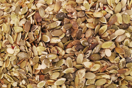 Pumpkin seed forming a background. Background texture of pumpkin seeds. Vegan food. Raw pumpkin seeds for roasting closeupの写真素材