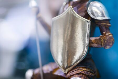 Ornate shield of a bronze statue belonging to a knight in armour. Warrior in armor with shield. Protection conceptの写真素材