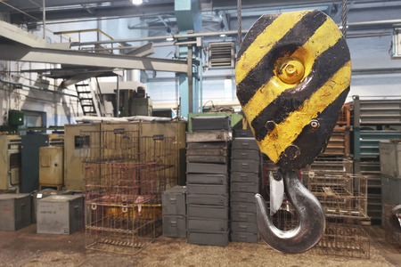 Metallic industrial hook for lifting heavy thing in the factory. Industrial yellow crane hook. Heavy duty crane hook of an old factoryの写真素材