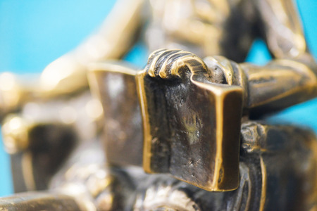 Closeup of the hand of a bronze statue holding an open book, small depth of field.の写真素材