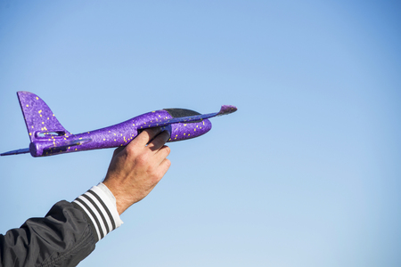 Toy airplane in hand of man and sky background. Toy airplane in the skyの写真素材