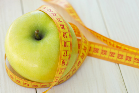 Dieting concept. Green apple with measuring tape.の写真素材